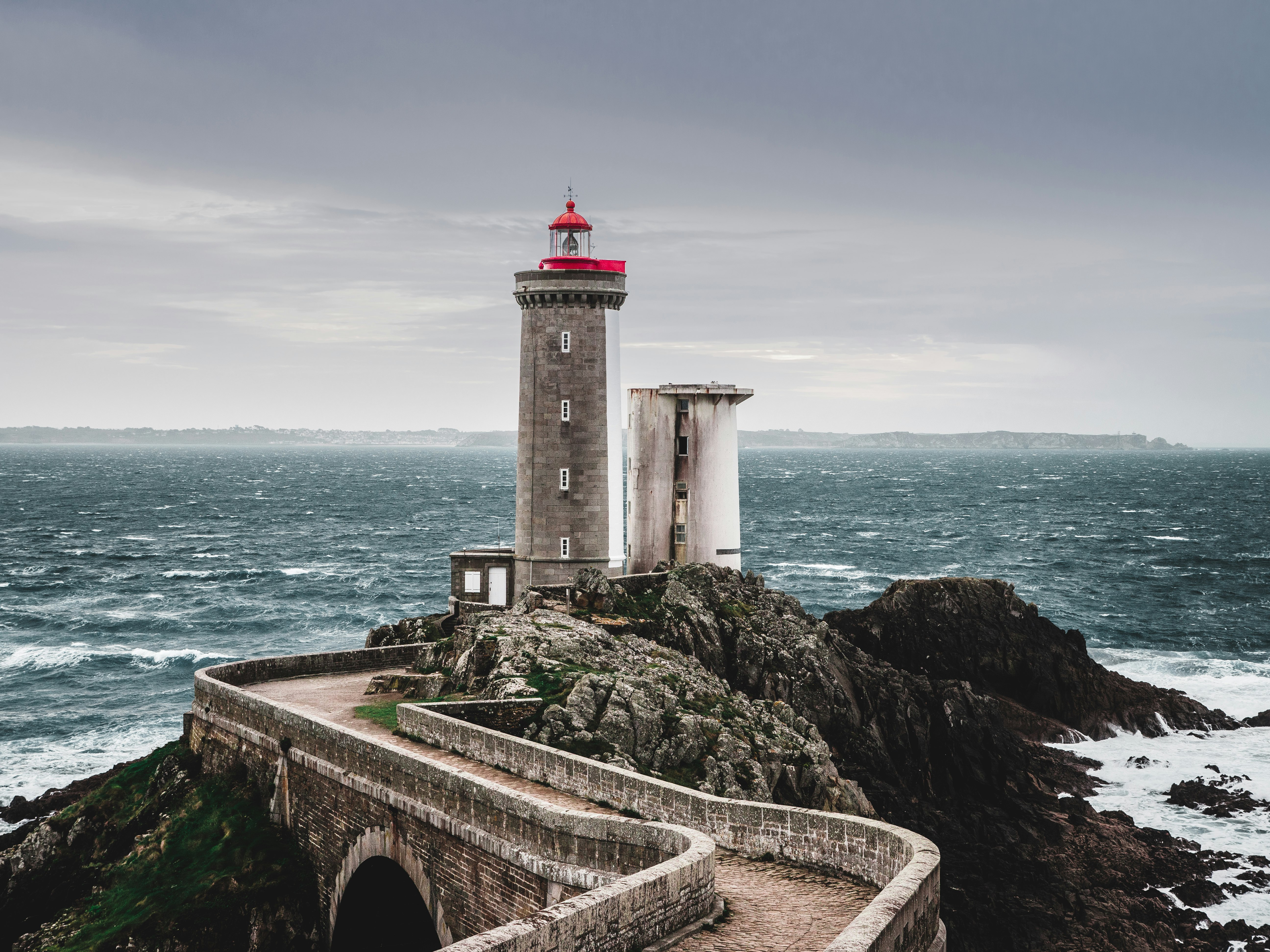 white and red lighthouse near body of water